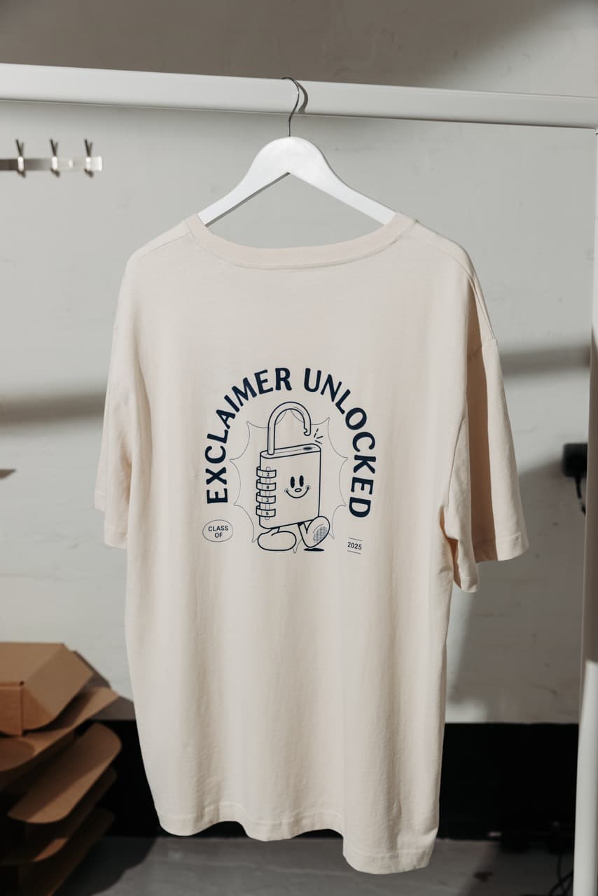 Cream branded t-shirt on a hanger with an 'Exclaimer Unlocked' print
