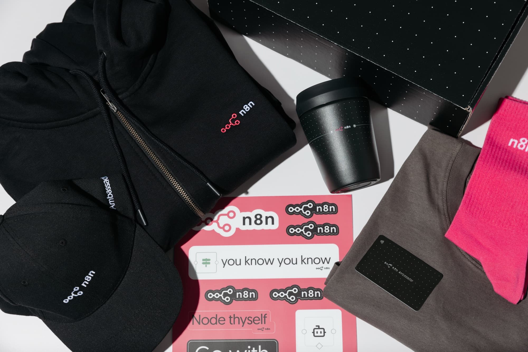 A full n8n branded swag pack: box, hoodie, cap and accessories