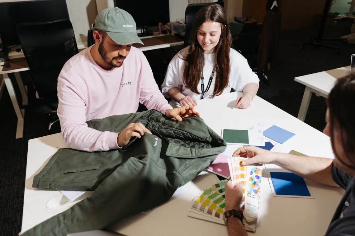 The Go Swag design team reviewing garment samples and Pantone swatches