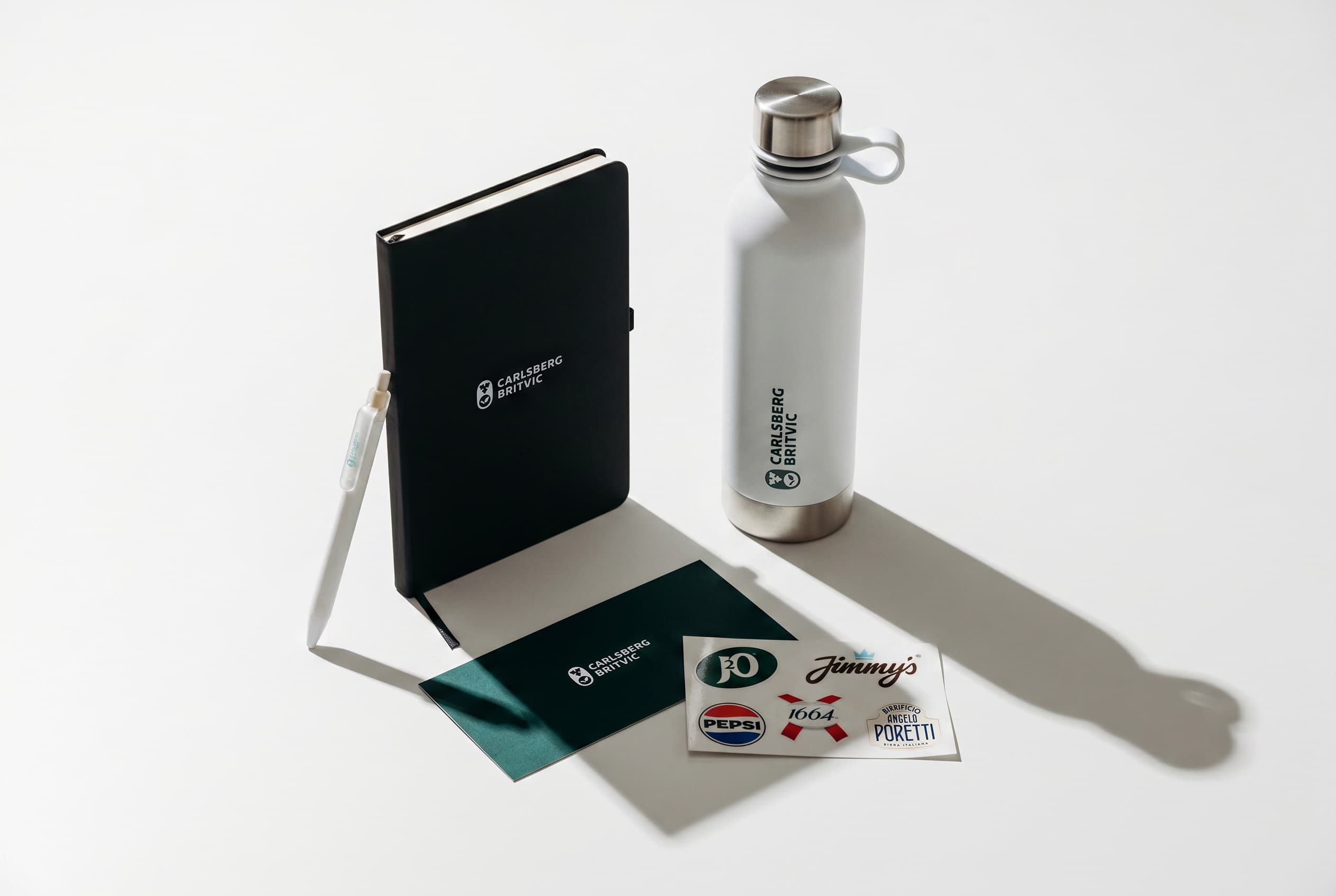 A branded Carlsberg Britvic notebook, bottle, pen and sticker sheet