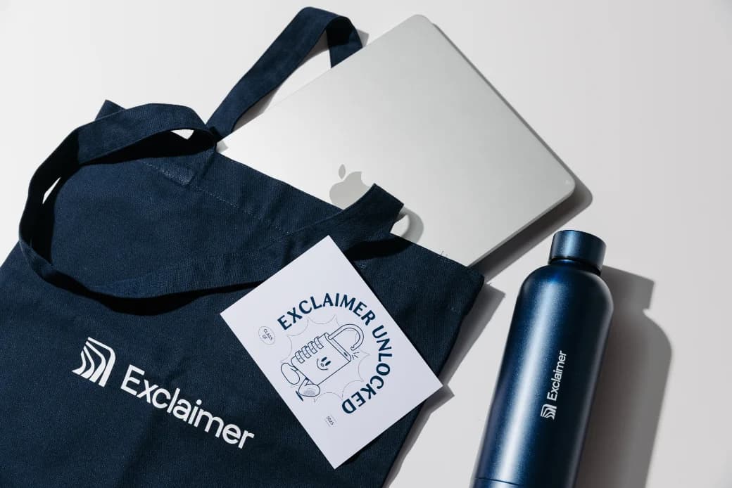 A branded tote bag, notebook and water bottle from an employee swag pack