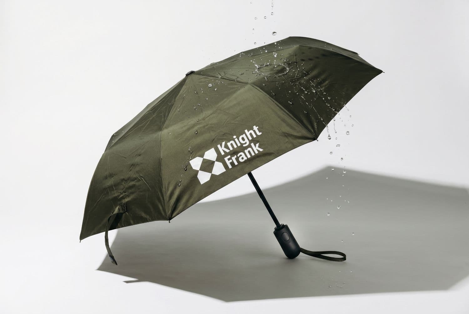 A branded Knight Frank umbrella in the rain