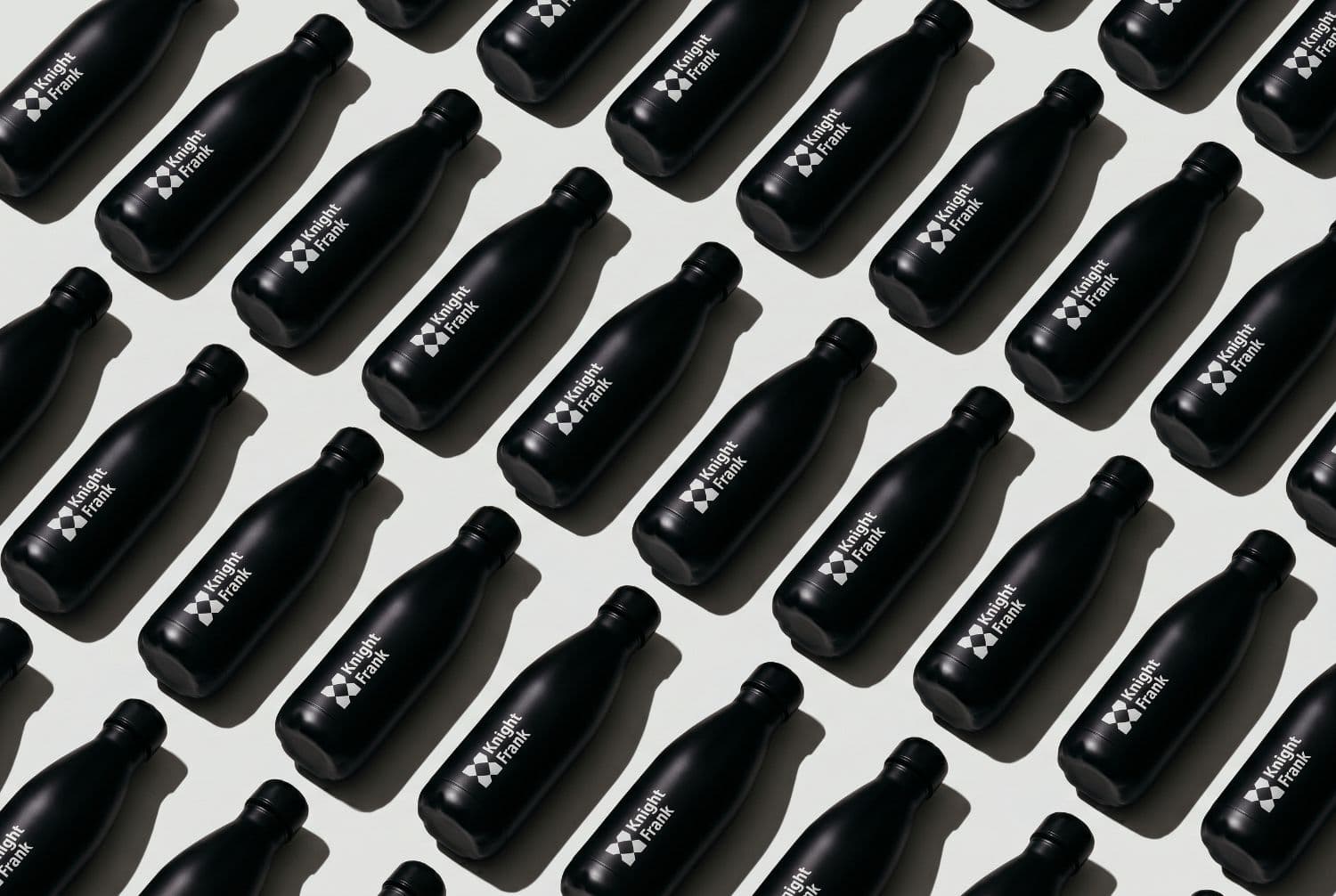 Branded Knight Frank insulated bottles laid out in a grid