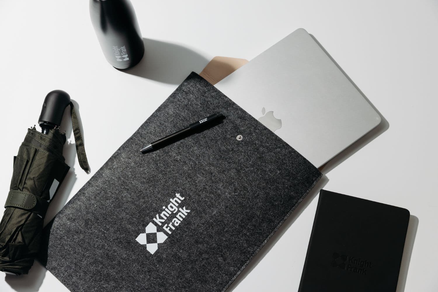 A full Knight Frank welcome pack: sleeve, bottle, notebook, pen and umbrella