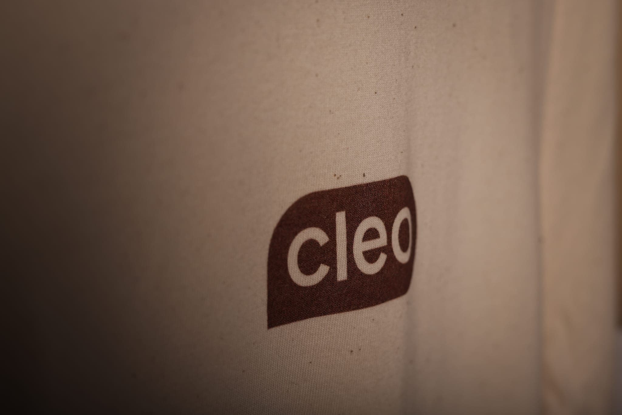 Close-up of a brown Cleo logo printed on cream cotton
