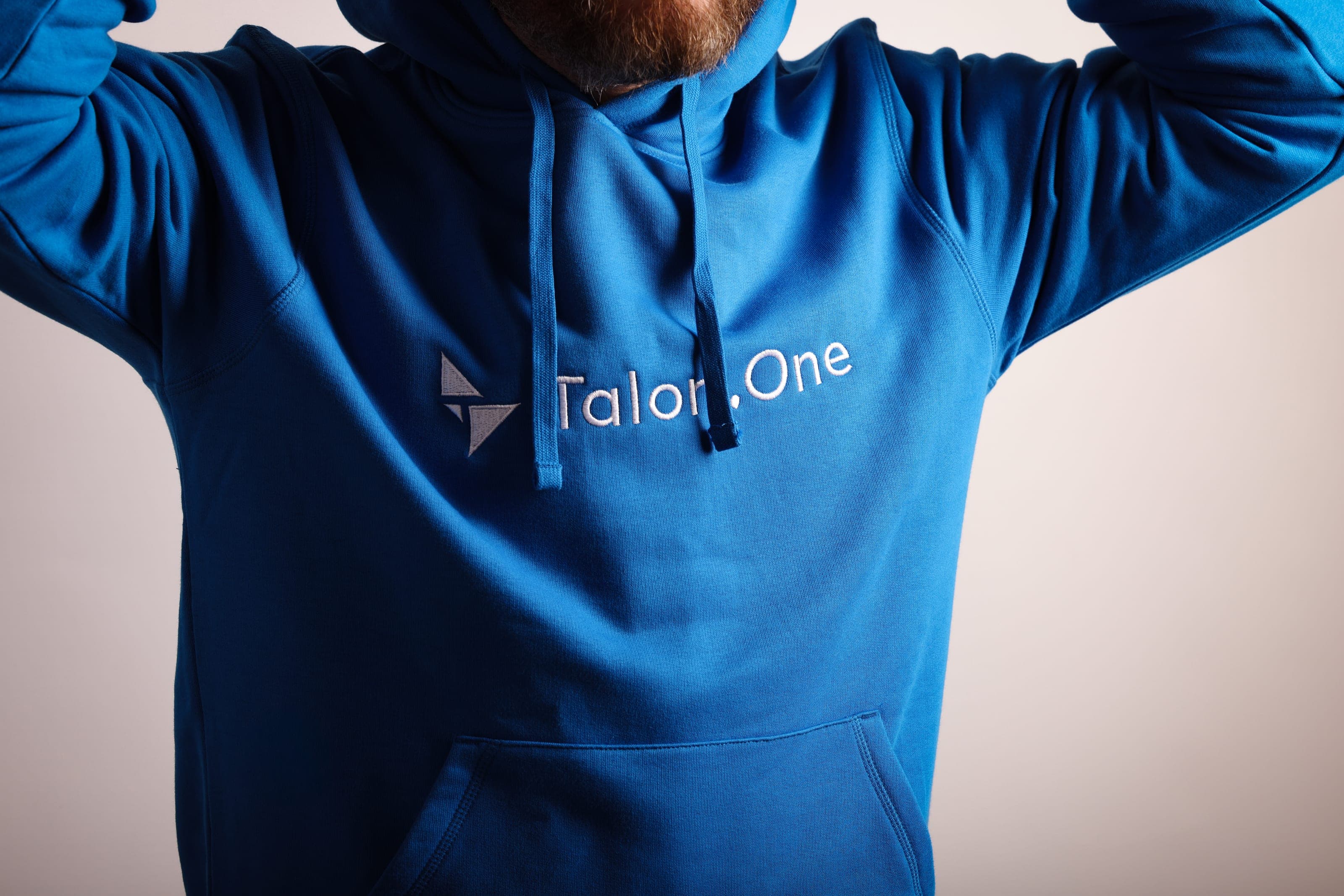 Bright blue hoodie with the Talon.One icon and wordmark embroidered on the chest