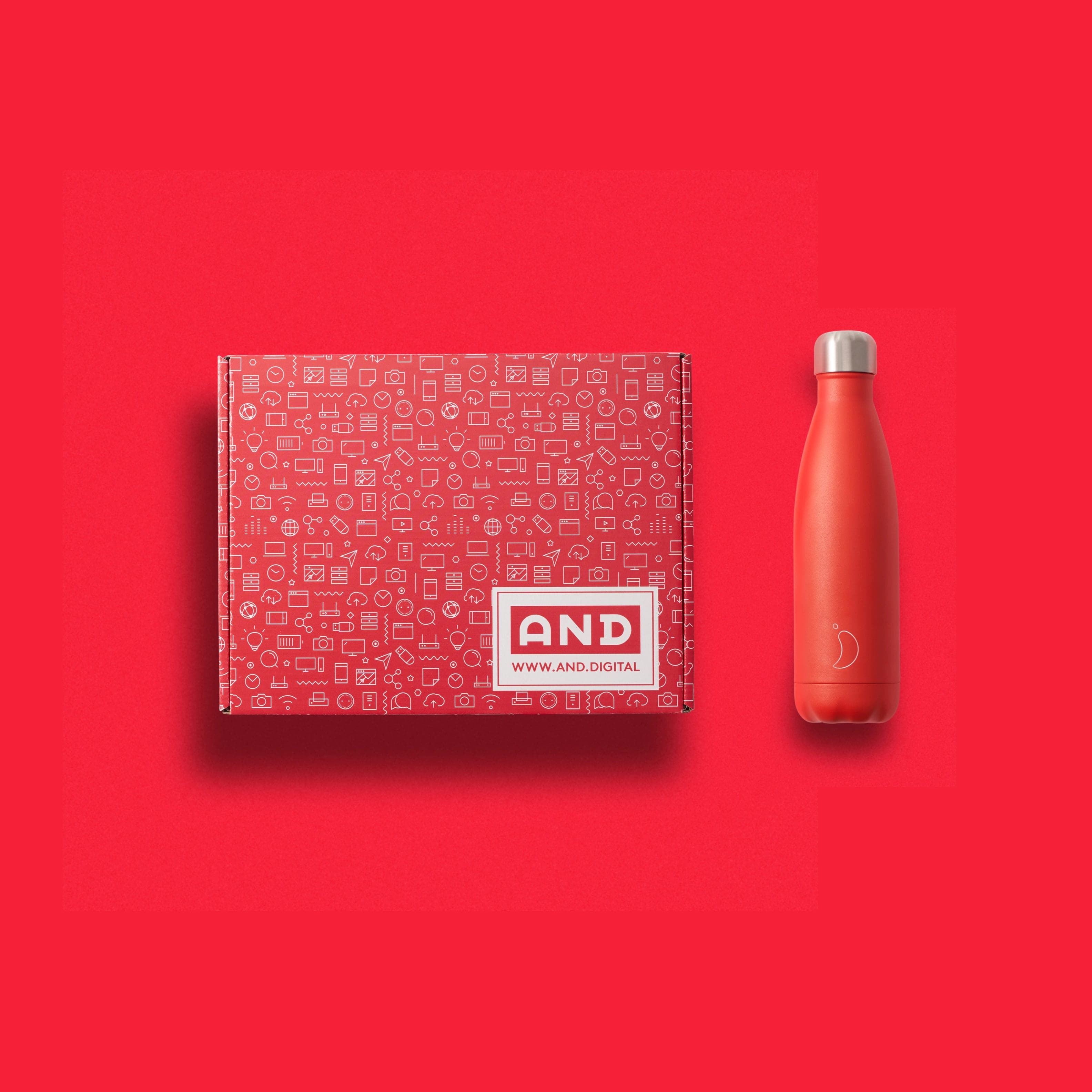 Red AND Digital patterned mailer box next to a matte red bottle on red