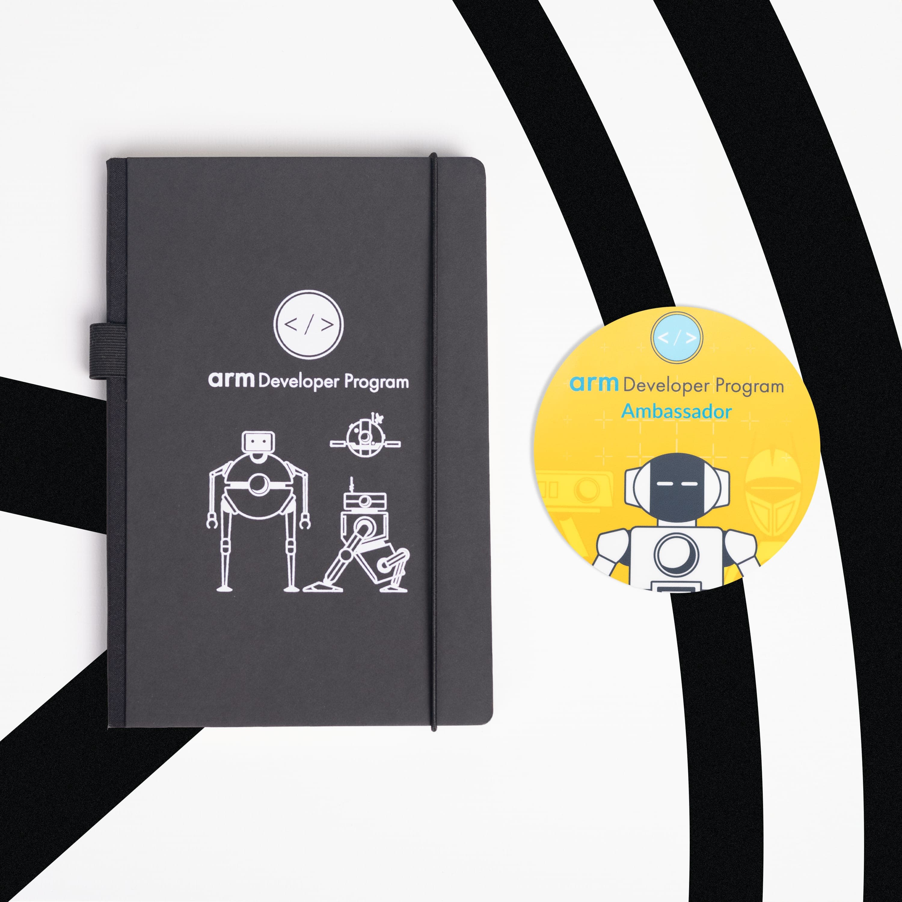 A black elastic-closure notebook with a white Arm Developer Program logo and line-drawn robots