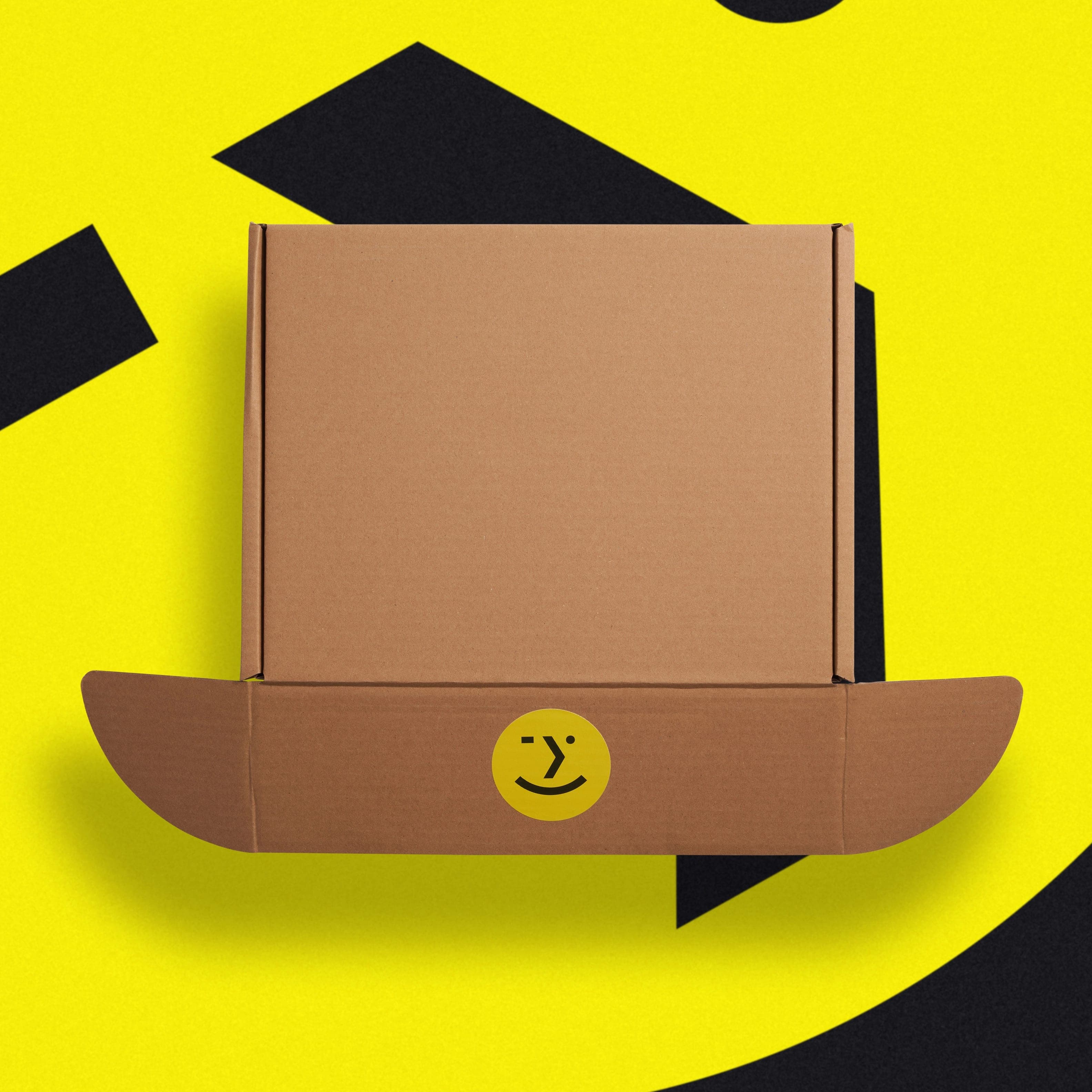 An open kraft mailer box closed with a yellow wink-face sticker