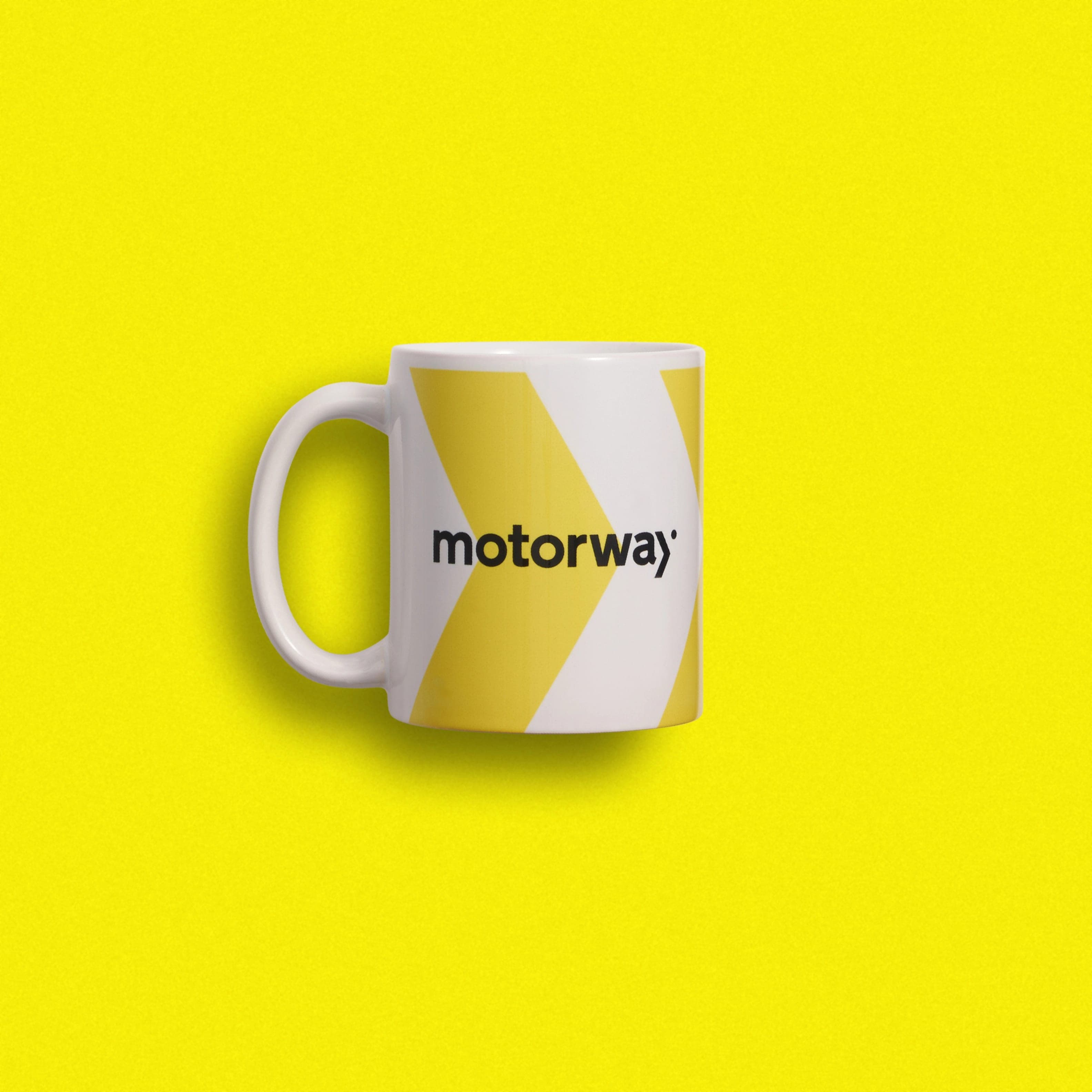 A white mug with yellow chevrons and a black Motorway wordmark