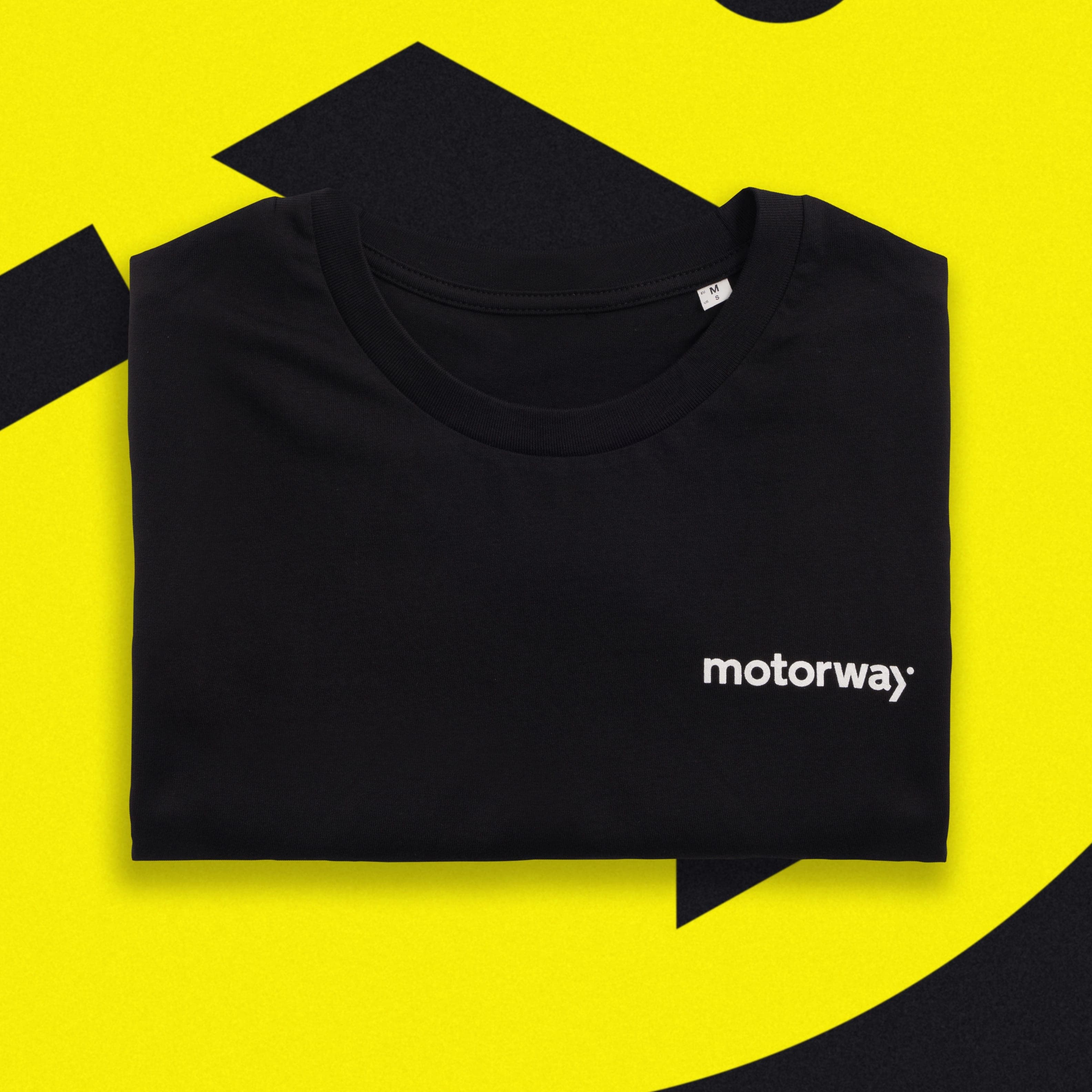 A folded black T-shirt with a small white Motorway wordmark on the chest