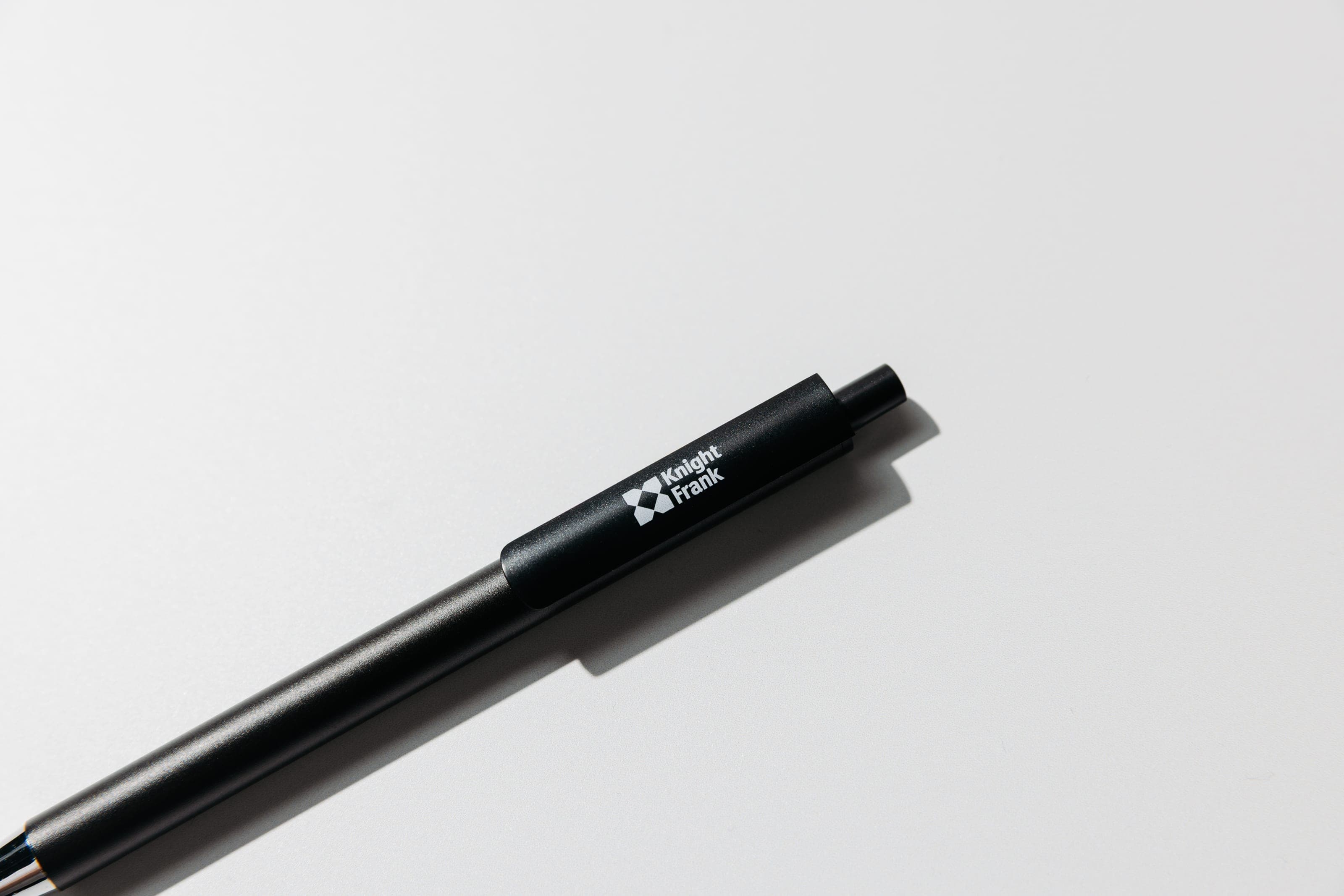 Close crop of a black pen barrel printed with a white Knight Frank logo