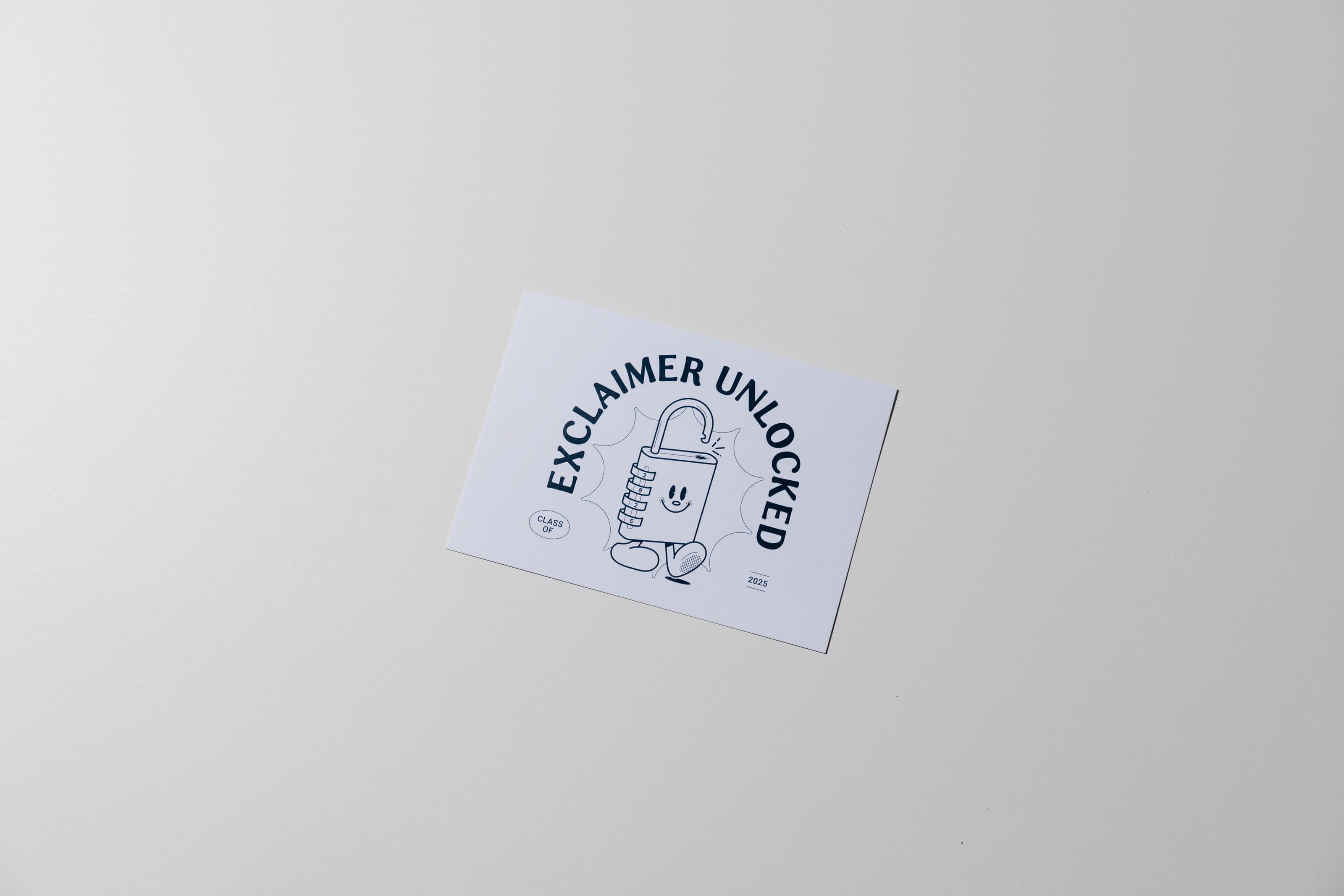 Exclaimer Unlocked card with a smiling padlock character and Class of 2025 on a pale surface