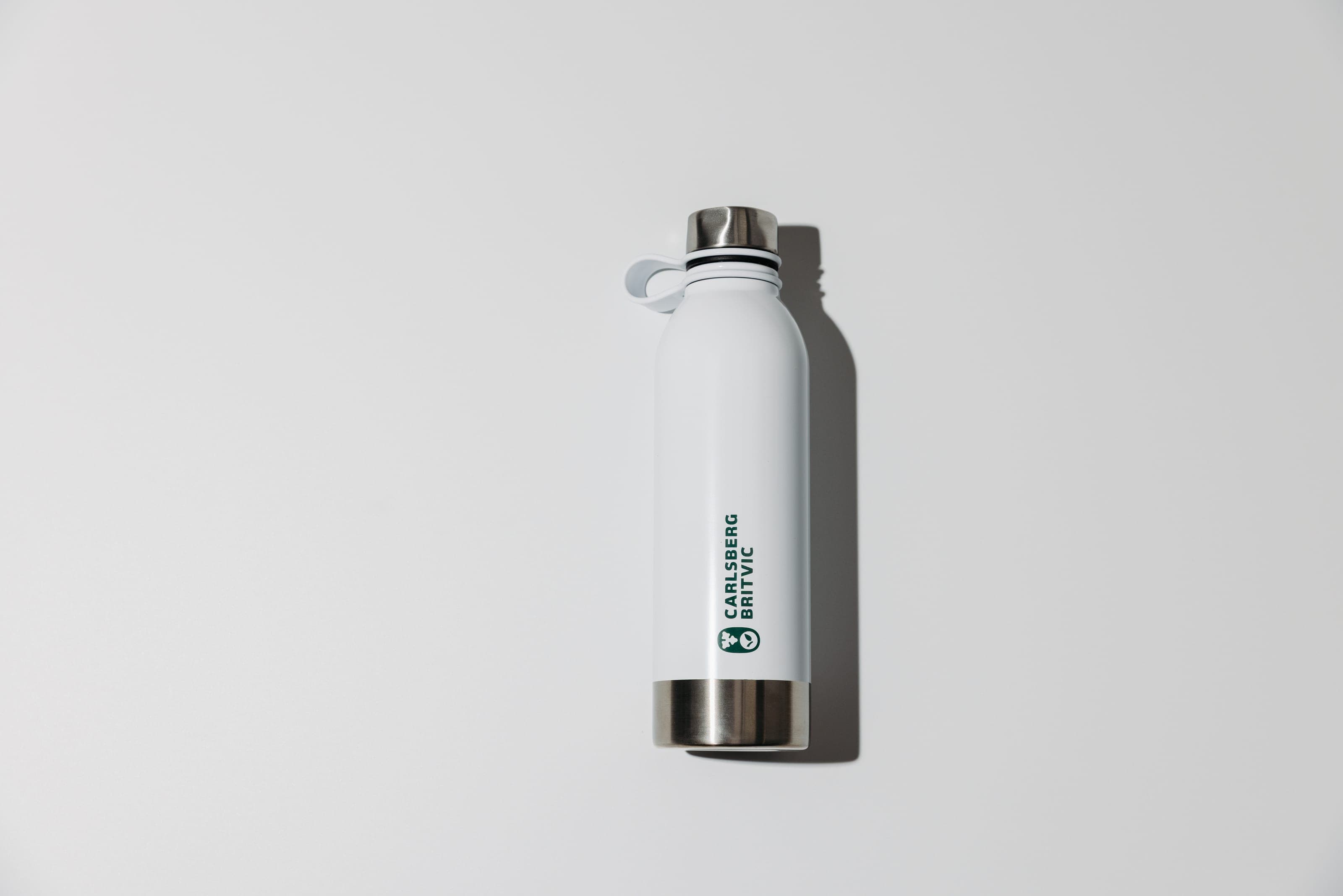 A white Carlsberg Britvic bottle standing on a white surface