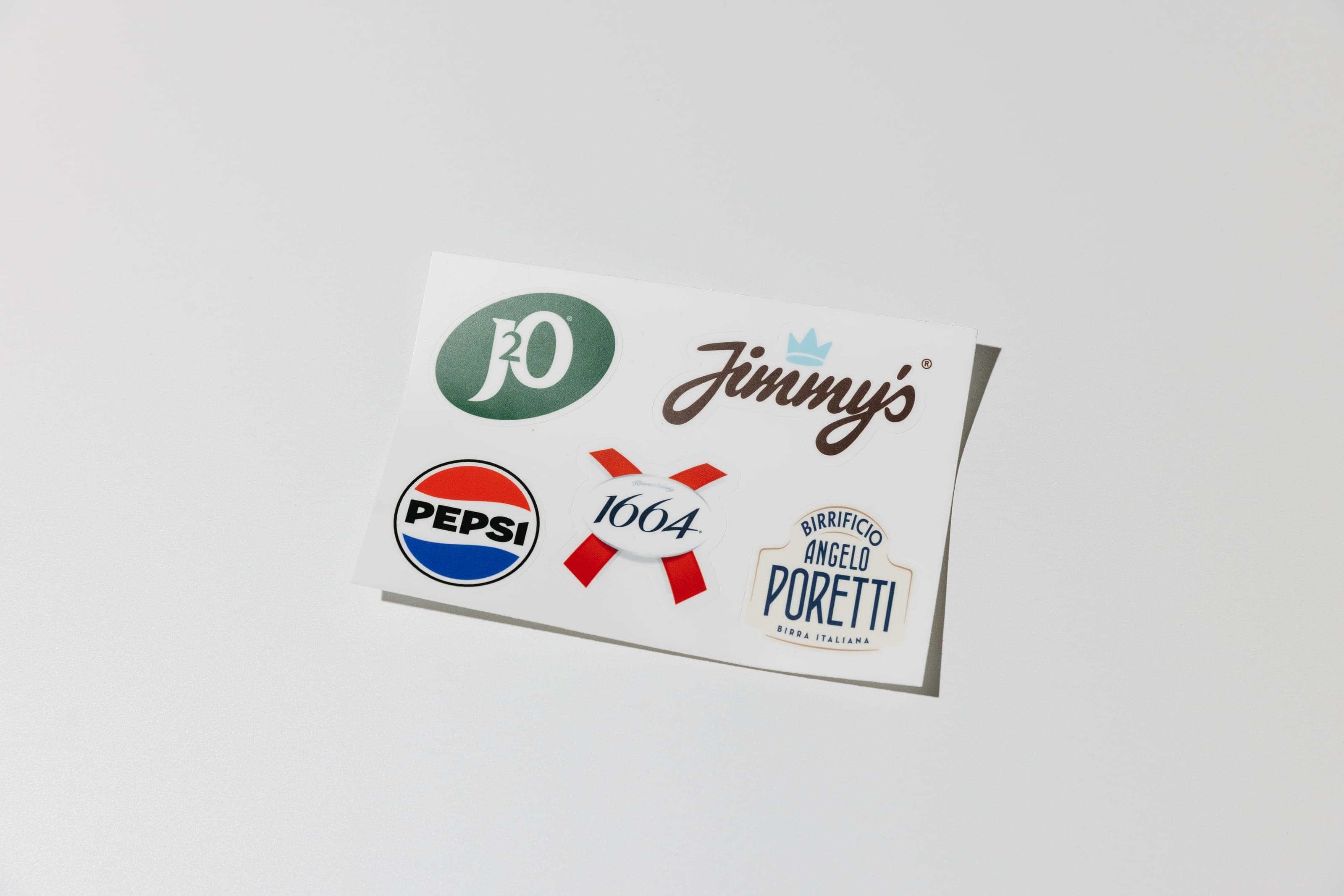 A sticker sheet with J2O, Jimmy’s, Pepsi, 1664 and Poretti stickers